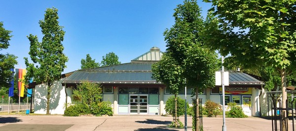 Foto Kfz-Zulassungsstelle von außen - einstöckiges Gebäude mit Dach in Zeltform.