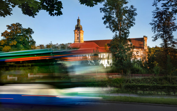 Foto zeigt Bus, der am Kloster Fürstenfeld vorbeifährt.