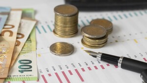 Banknoten und Münzen liegen auf einem Dokument mit Bilanzen.