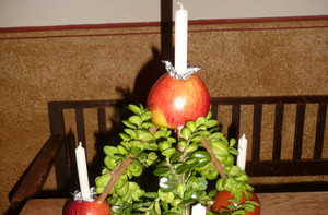 Gesteck aus Zweigen und Äpfeln mit Kerzen