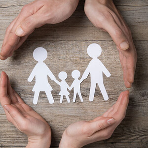 Vier Hände formen einen Kreis: In der Mitte symbolhafte Darstellung von zwei Kindern mit Mutter und Vater.