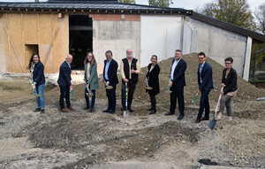 Verantwortliche stehen mit Sparten auf der Baustelle.