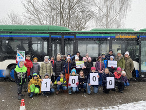25 Grundschulkinder und vier Erwachsenen vor einem Bus