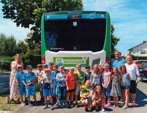 Grundschulkinder stehen vor MVV-Bus.