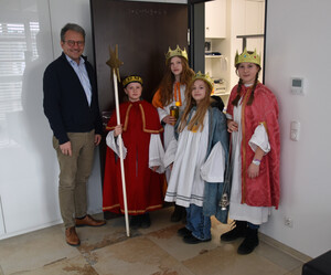 Sternsinger stehen vor der Büro-Türe des Landrats.