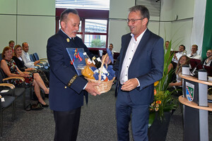 Landrat Thomas Karmasin überreicht an Hubert Stefan einen Geschenkkorb.