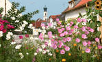 Blumenumrankter Blick auf den Ortskern von Moorenweis