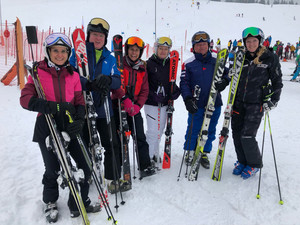 Gruppenfoto:; Vier Frauen und  zwei Herren in Skianzügen, stehend mit Skiern
