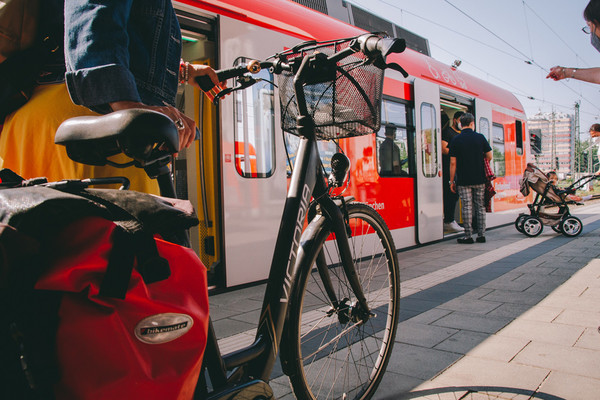 Am Bahnsteig: Radfahrer mit Fahrrad steht vor dem Einstieg zu einer haltenden S-Bahn. Foto: MVV