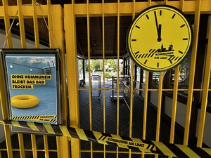Uhr am Eingang des FZP Mammendorf zeigt fünf vor 12 an.