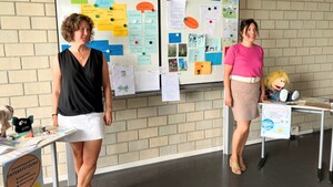 2 Frauen stehen vor einer Schultafel