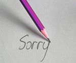 Symbolfoto: Bleistift schreibt auf Papier Sorry