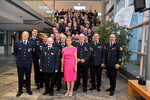 Gruppenfoto. Rund 60 Personen in Feuerwehranzügen auf einer Treppe versammeltuf eine Treppe
