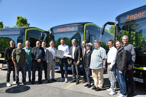 Personen stehen vor neuen E-Bussen.